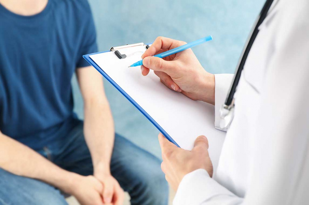 Врач-уролог записывает жалобы пациента