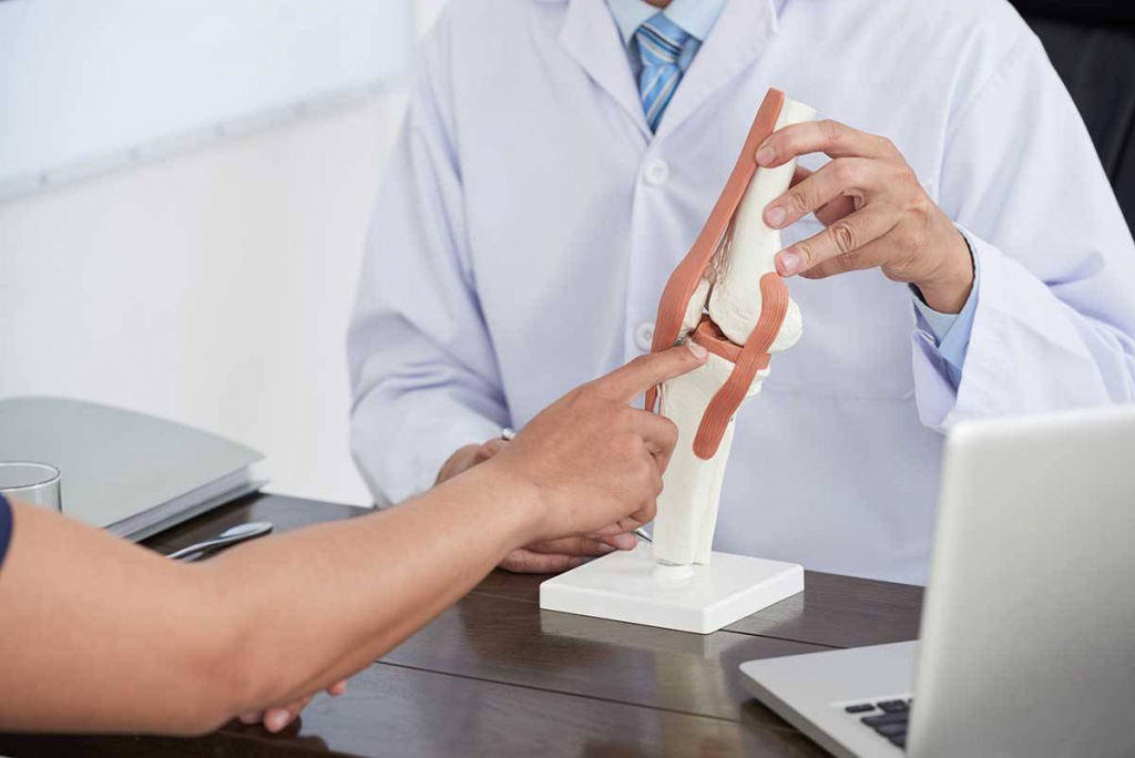 Врач объясняет пациенту, что такое синовит суставов