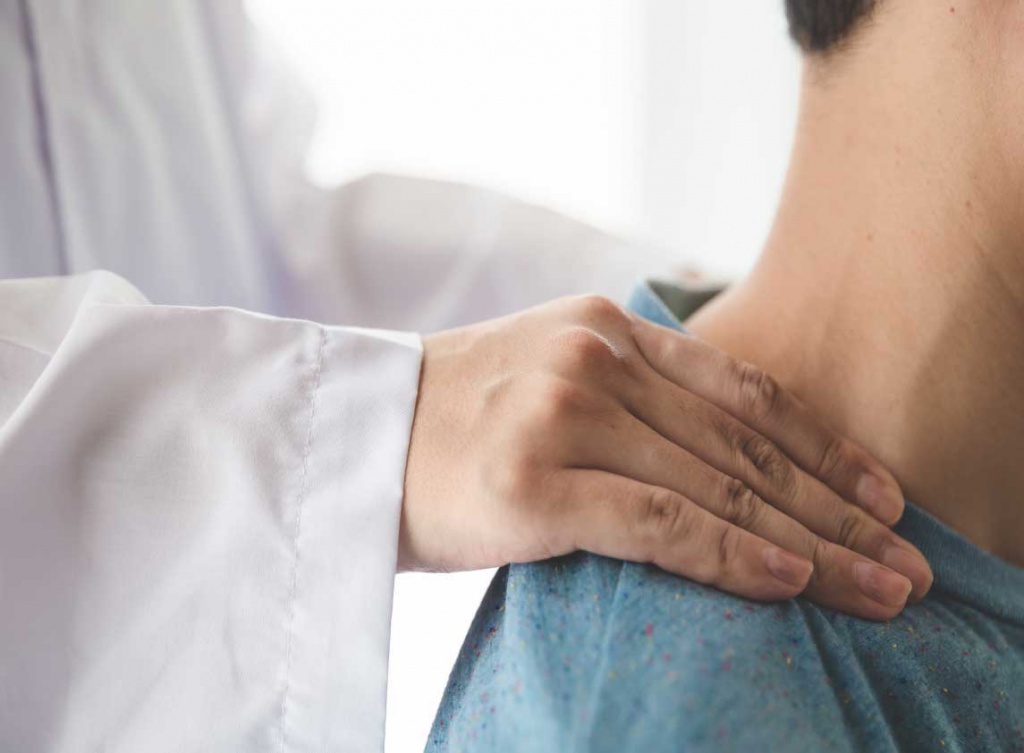 Врач ортопед проводит диагностику сколиоза шейного отдела позвоночника